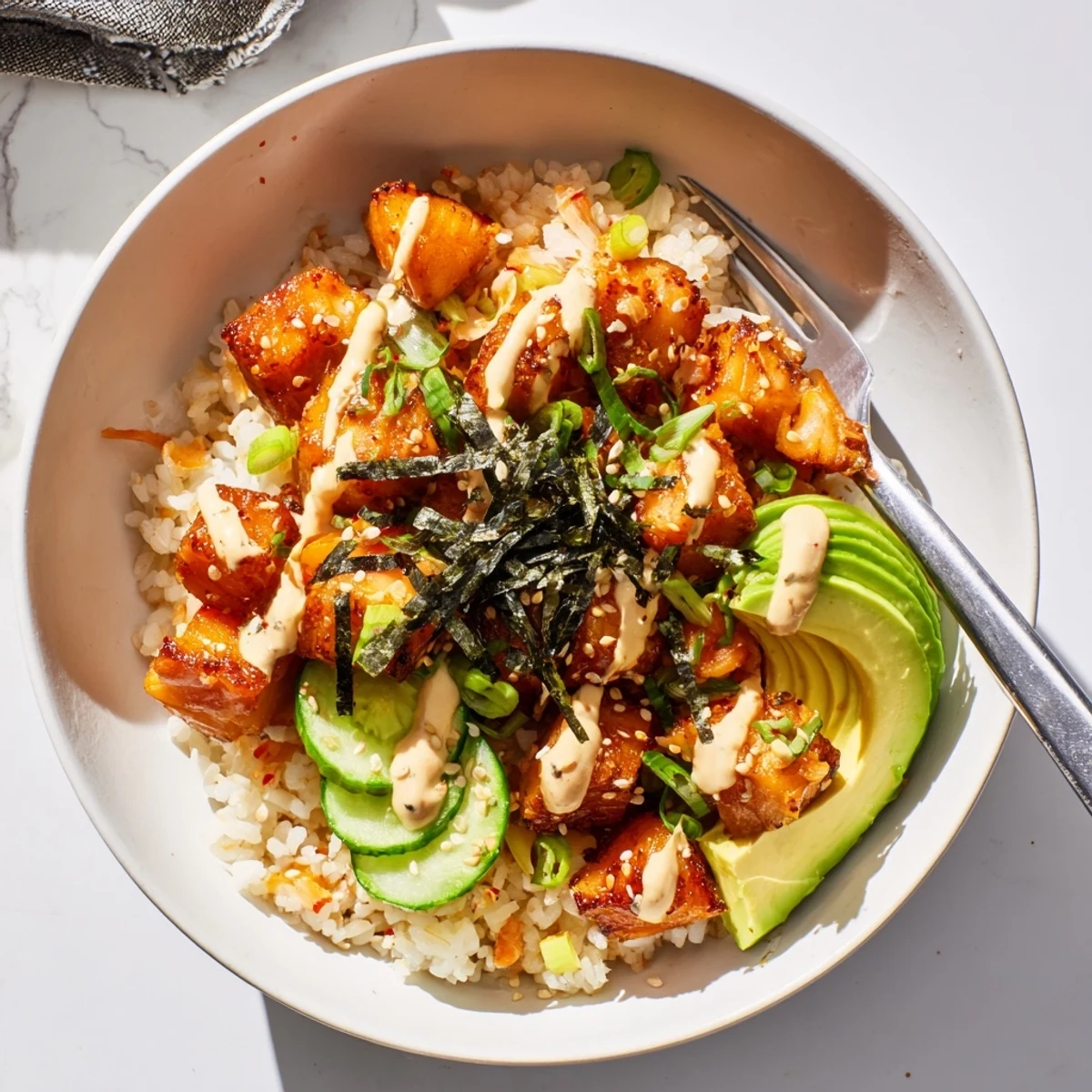 Delicious crispy salmon rice bowl featuring fluffy rice and spicy mayo drizzle.
