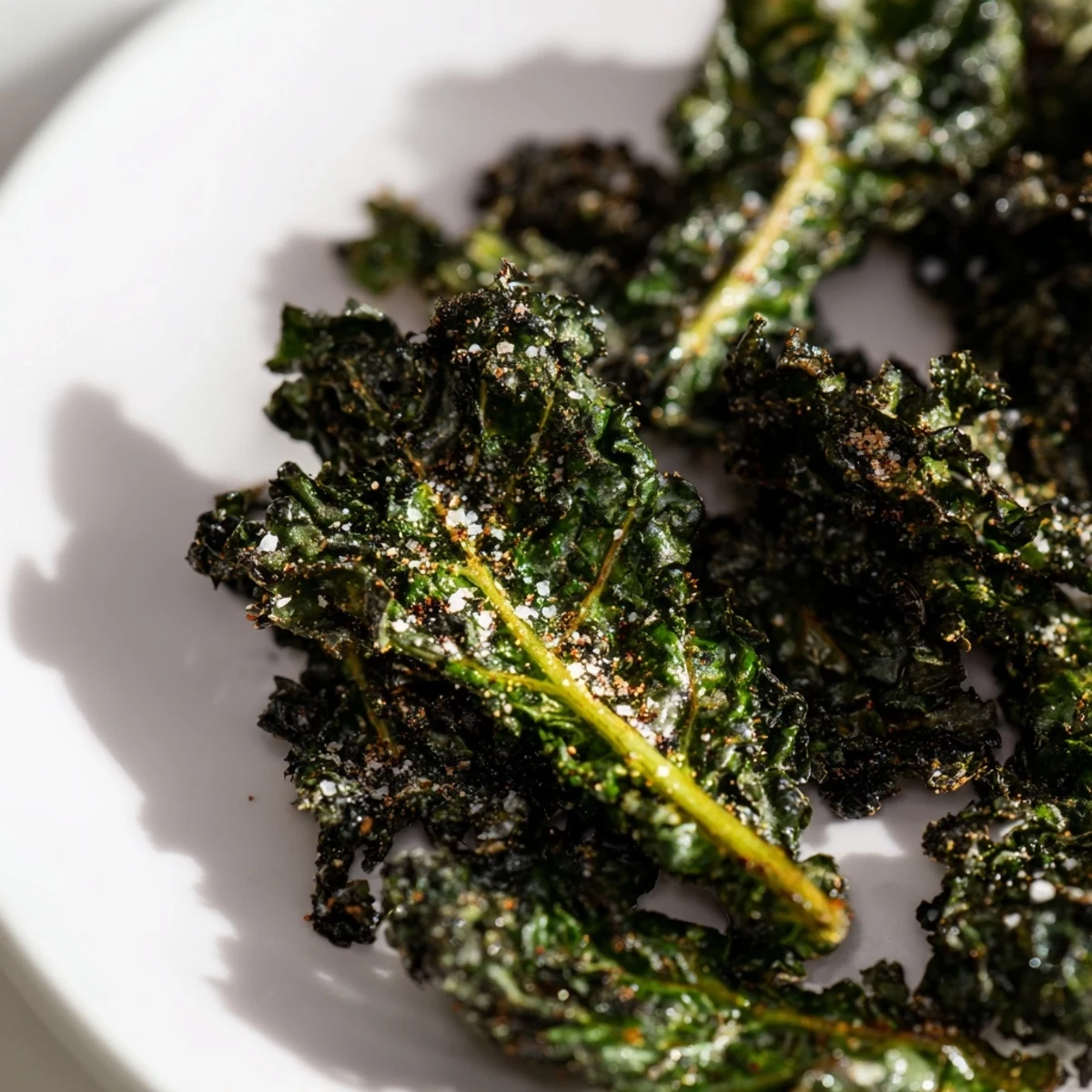 Golden-brown Baked Kale Chips, crispy and salty, ready to be enjoyed as a healthy snack.