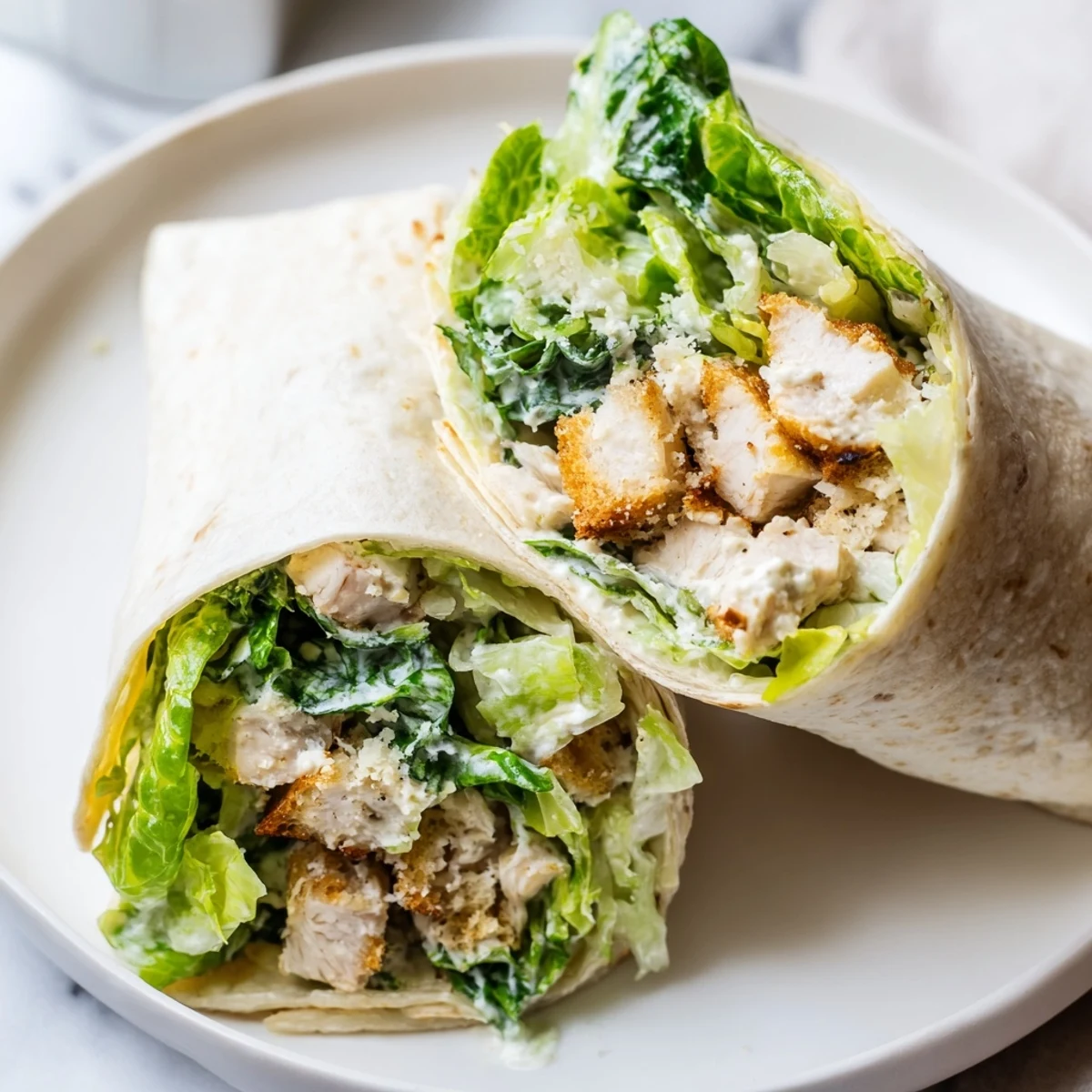 A close-up of a Chicken Caesar Wrap, cut in half to display the layers of ingredients for a delicious bite.