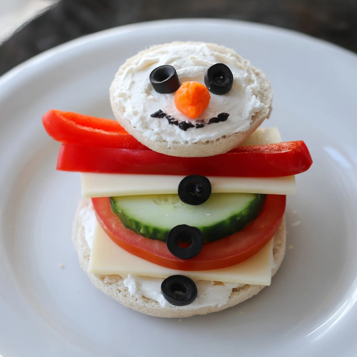 A cheerful Snowman Sandwich Stack, crafted with olives, carrots, and bell pepper, ready to eat.