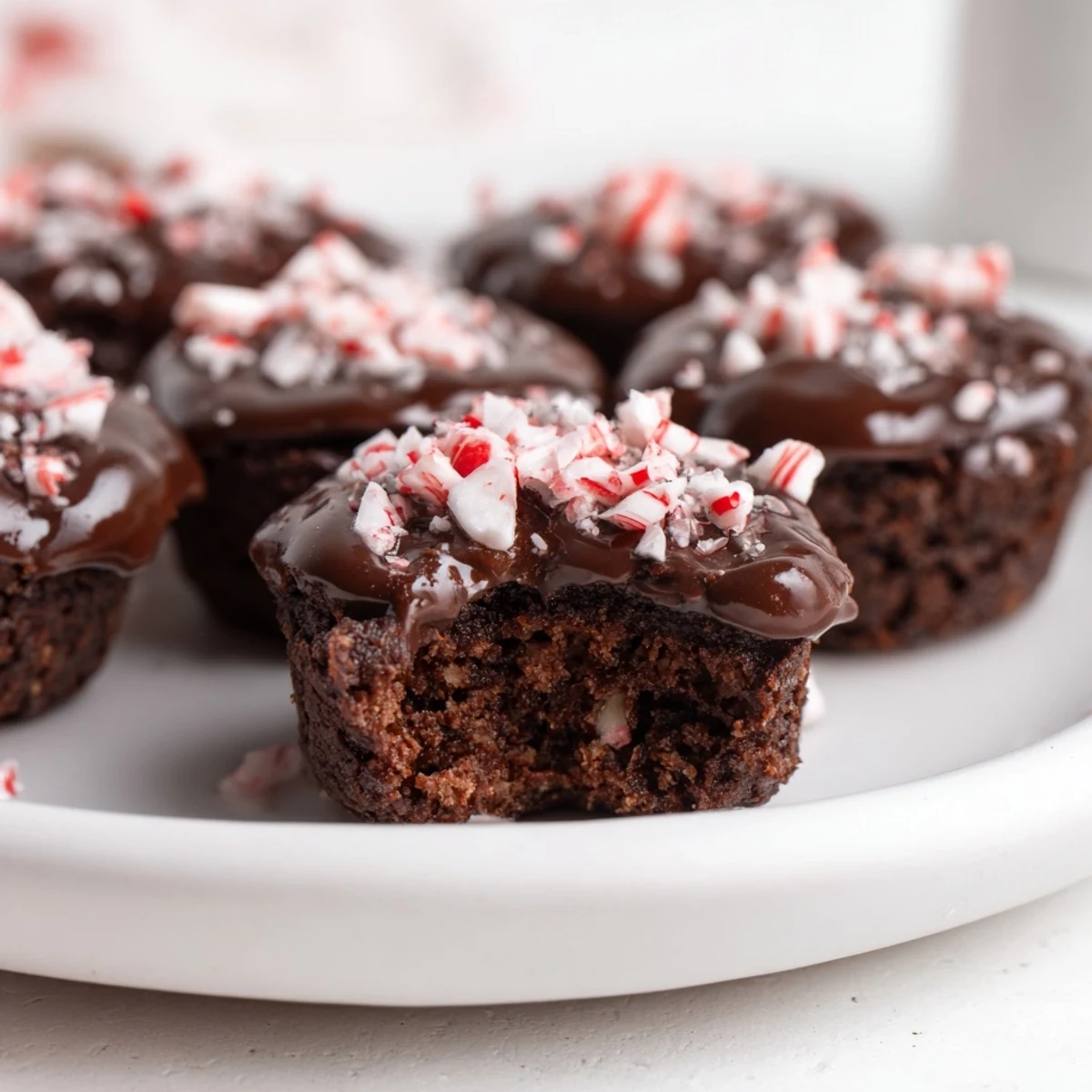Fudgy Peppermint Mocha Brownie Bites, drizzled with chocolate glaze, offering a taste of holiday cheer.