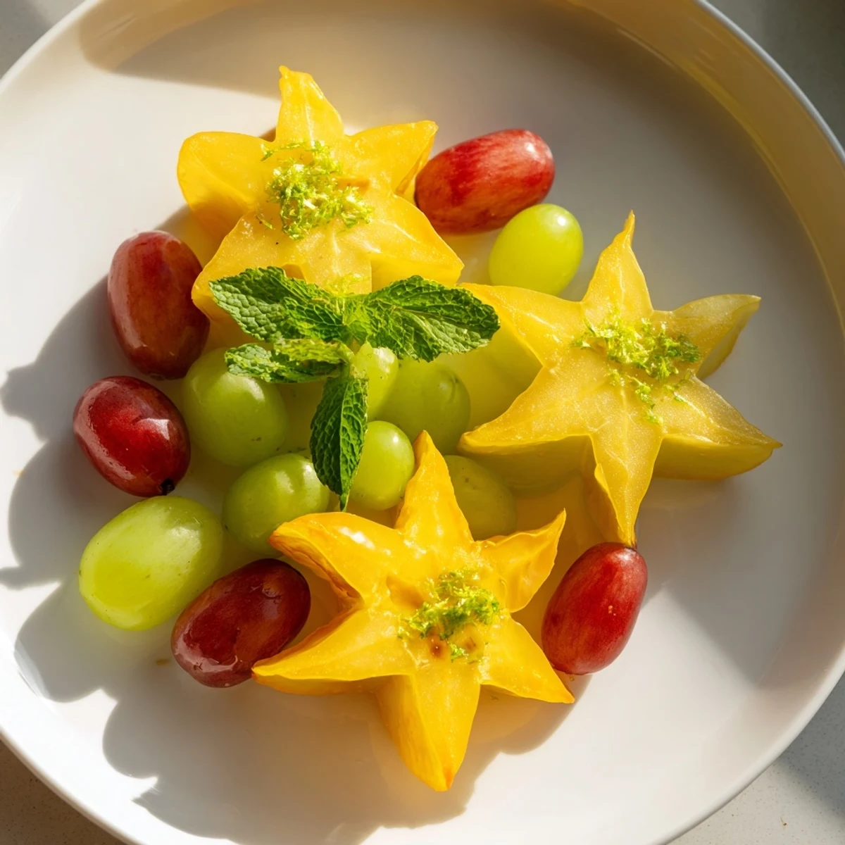 A visually stunning plate of brunch fruit, showcasing sliced starfruit and refreshing green grapes.