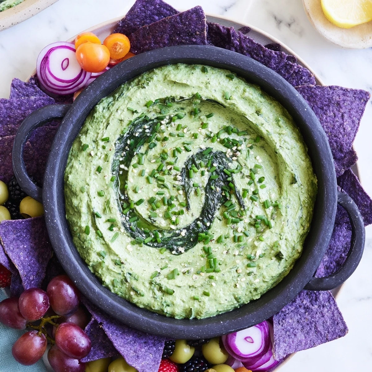 Vibrant green Witch's Brew Cauldron dip served in a black bowl, surrounded by dark, spooky Halloween snacks.