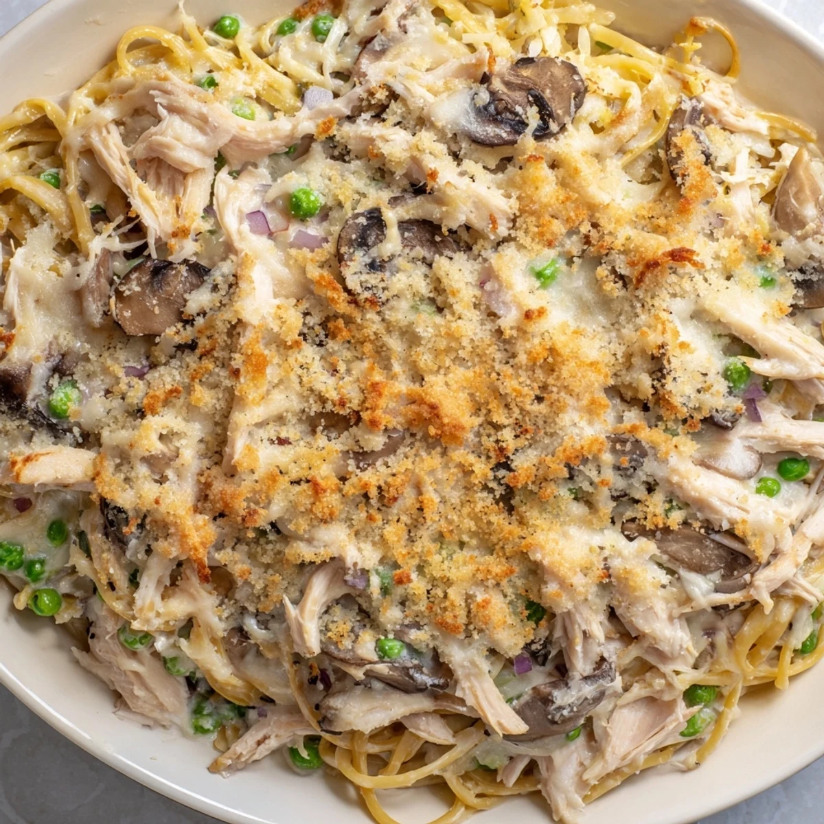 Golden-brown Turkey Tetrazzini sits in a baking dish, a creamy, cheese-topped casserole.