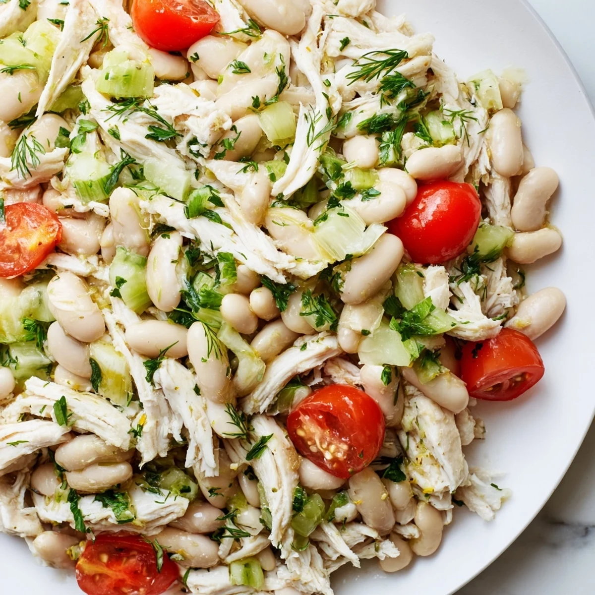 A close-up of Lemony White Bean Chicken Salad, featuring tender shredded chicken, creamy white beans, and crisp celery in a bright vinaigrette.