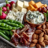 Vibrant spring charcuterie board featuring radishes, peas, and herb dip—perfect for entertaining with fresh, seasonal produce and flavorful accompaniments.