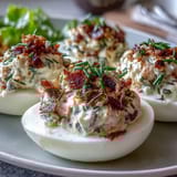 Smoked salmon deviled eggs garnished with fresh chives and everything seasoning, an elegant appetizer for any occasion.