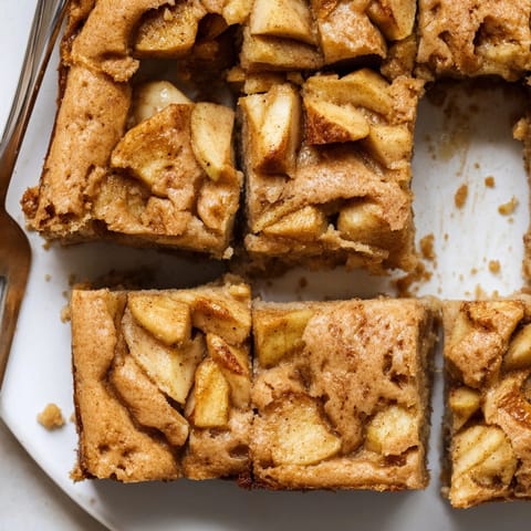Warm, gooey Brown Butter Apple Blondies, sliced and ready to serve with vanilla ice cream.