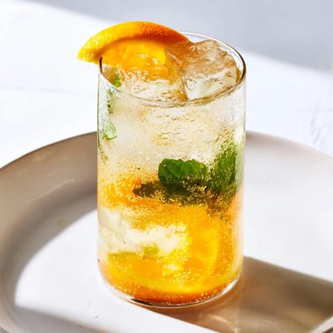 Brightly colored probiotic soda mocktail garnished with mint, perfect for summer refreshment.  