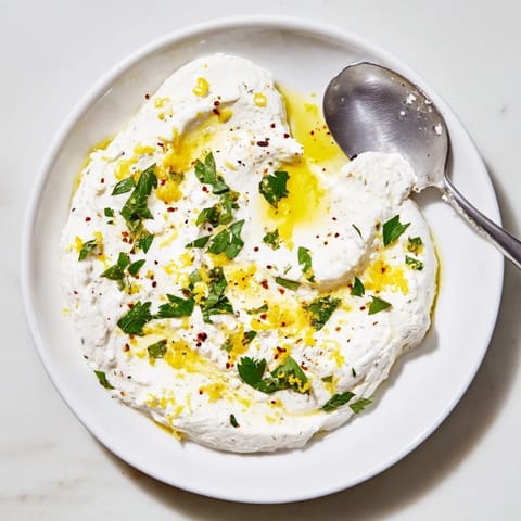This easy Whipped Feta recipe offers a smooth, flavorful appetizer adorned with fresh herbs.