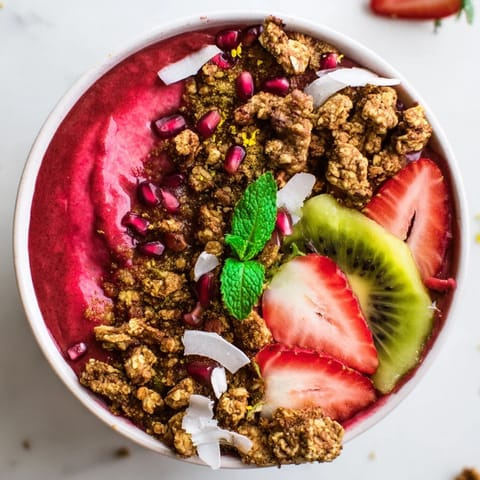 This vibrant Festive Red and Green Smoothie Bowl features a beautiful mix of red berry and green kiwi layers.