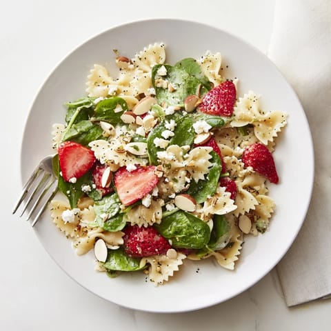 Bow-tie pasta is coated in a tangy poppy seed dressing, topped with crumbled feta and fresh basil.
