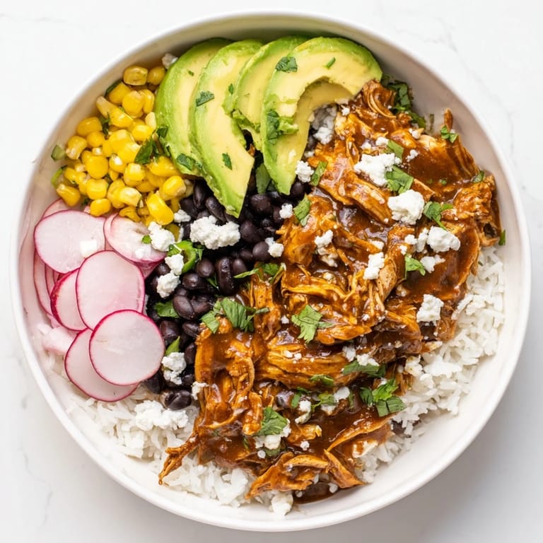 This colorful Green Enchilada Rice Bowl features chicken smothered in green sauce, ready to be devoured.