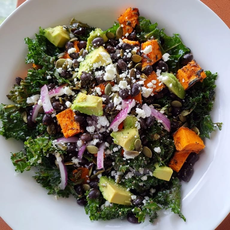 Delicious massaged kale salad: colorful sweet potato, filling black beans, and creamy avocado ready to enjoy.