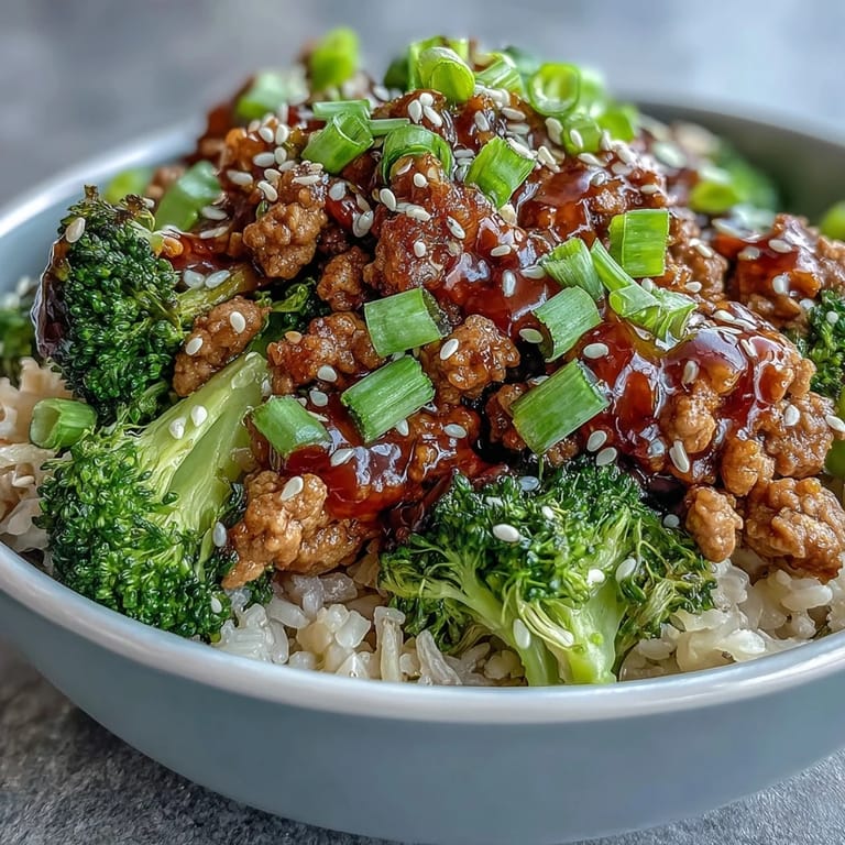 Close-up of Sweet and Spicy Turkey Broccoli Bowls reveals sautéed turkey, fresh ginger and garlic aromas, and bright green broccoli florets mixed into steaming rice.